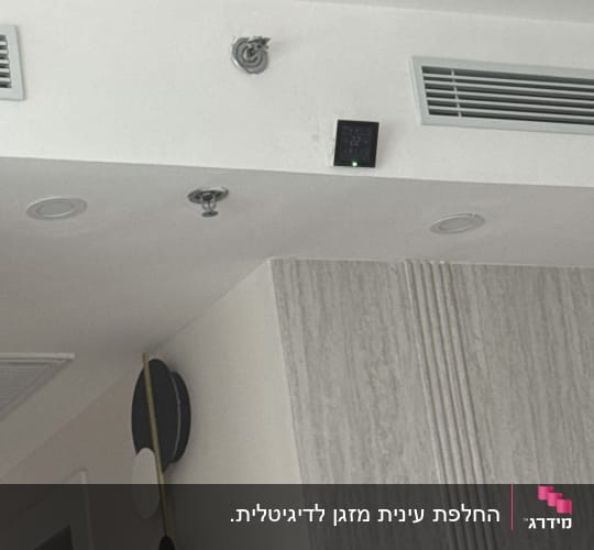 מערכת מיזוג אוויר עם תרמוסטט על קיר לבן